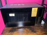 a microwave that is sitting on a wooden table