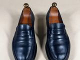 a pair of blue loafers on a white surface