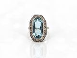 une bague sertie d'une topaze bleue et de diamants sur fond blanc