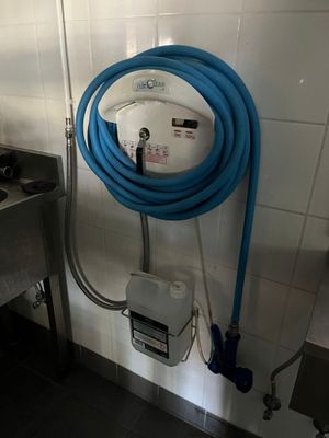 un tuyau bleu fixé au mur dans les toilettes publiques