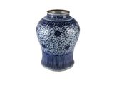 un vase bleu et blanc posé sur une surface blanche
