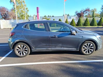 La voiture grise est garée sur le parking, la portière ouverte.
