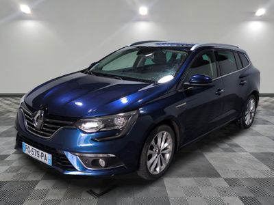 La voiture bleue est garée dans une grande pièce dont le sol est en damier.