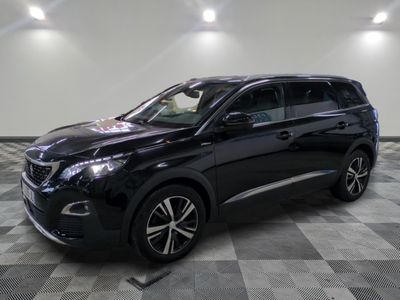 Un SUV noir est garé dans une grande pièce au sol carrelé.