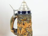 a blue and yellow beer mug with a spoon in it