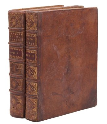 an old book with a brown cover sitting on top of a white surface