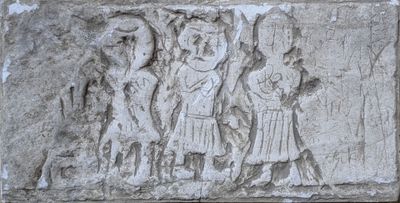 une image représentant un relief en pierre sur lequel figure un groupe de personnes