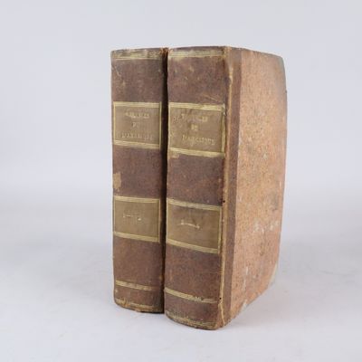 deux vieux livres posés l'un sur l'autre sur une surface blanche