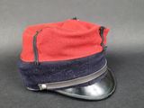une image représentant un chapeau rouge et bleu posé sur une surface noire