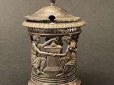 a silver vase with a lid that has a design on it