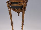 an antique brass and black lamp on a stand with a light on top