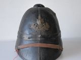 an old black helmet with a leather band and a star on it