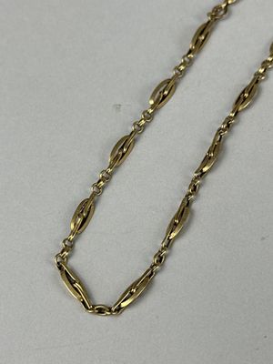 a close up of a gold chain on a white surface