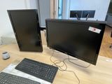 two computer monitors and a keyboard on a desk