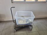 a small cart with a plastic container on it