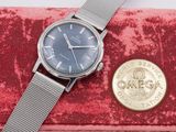 an image of a watch and a coin sitting on a red velvet case