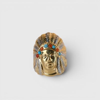 un gros plan d'une bague en or ornée d'une tête d'Indien