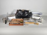 un sac à main noir posé sur une table, à côté d'un ensemble d'outils
