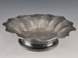 an antique silver plate with a flower design on it