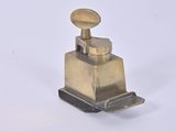 a small brass object on a white surface