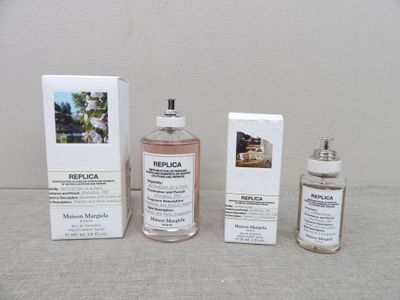 trois flacons de parfum posés sur une table, à côté d'une boîte
