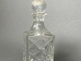 an image of a clear glass perfume bottle on a gray surface