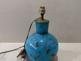 un petit vase bleu surmonté d'une lampe