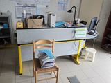 un bureau avec une chaise, dans une pièce où se trouvent de nombreuses boîtes