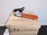 an orange chainsaw sitting on top of a wooden box