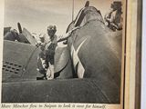 an old photo of a man standing in front of a plane