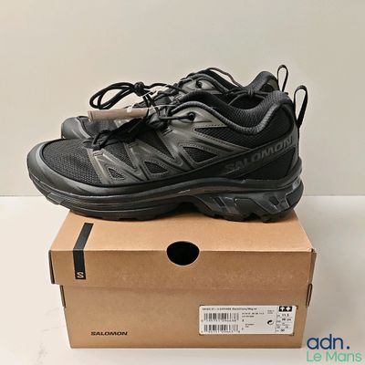 une paire de chaussures noires posée sur une boîte en carton