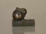 a small bronze sculpture of an apple sitting on a block