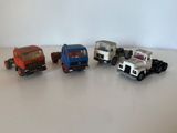 quatre camions miniatures alignés sur une table