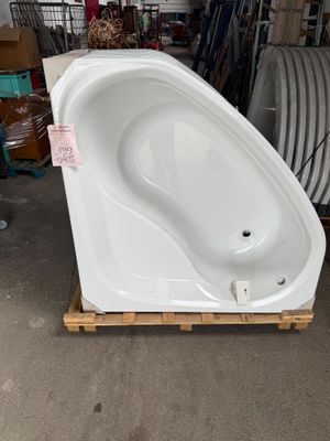 une baignoire blanche posée sur une palette dans un entrepôt