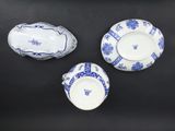three pieces of blue and white china on a black surface