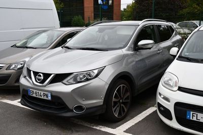 several cars parked in a parking lot next to a white van