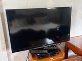 une télévision à écran plat posée sur une table en bois
