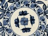 a blue and white plate with a floral design on it