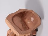 a small statue of a man with a bowl on his head