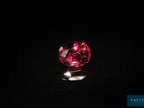 a close up of a red diamond on a black surface