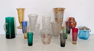 many different colored glass vases and cups on the table