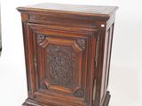 a small wooden cabinet with a carved design on it