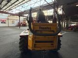 a picture of a man driving a tractor inside of a building