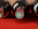 several bottles of wine are lined up on a red surface