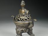 an ornate bronze incense box with a bird on top