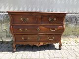 une commode marron posée sur un sol en briques