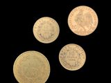 four different types of coins on a black background