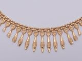 a close up of a gold necklace on a white surface