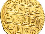a close up of a gold coin with arabic writing on it
