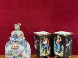 trois vases posés sur une table près d'un mur rouge